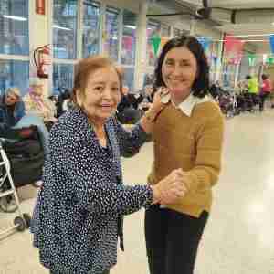 Una educadora ballant amb una dona gran durant una activitat.